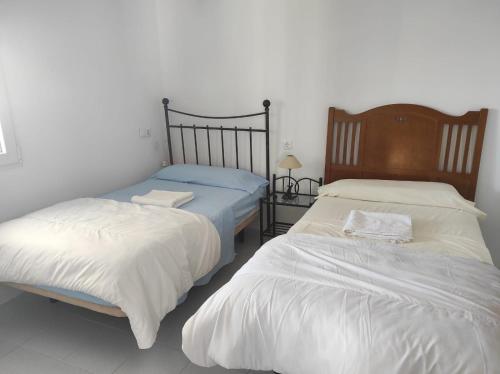due letti uno accanto all'altro in una camera da letto di Casa Rural con Piscina Verdugo a El Puerto de Santa María