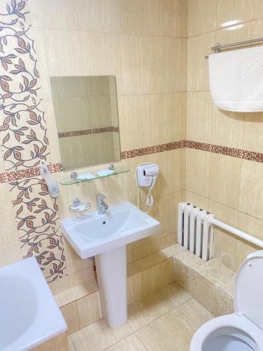uma casa de banho com um lavatório e um WC em Belon inn em Astana