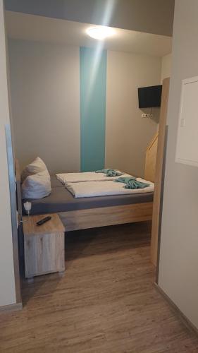 a bed in a room with a blue wall at Landgasthof und Pension Zum löwen in Bischofsheim an der Rhön