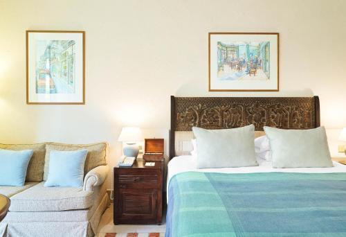 a hotel room with a bed and a couch at Columbia Beach Resort in Pissouri