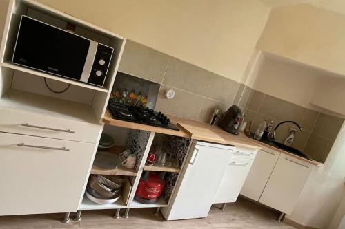 a kitchen with white cabinets and a microwave at Maison de village Azillanet in Azillanet