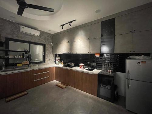 - une cuisine avec des placards en bois et un réfrigérateur blanc dans l'établissement Nhà mình Homestay, à Rạch Giá