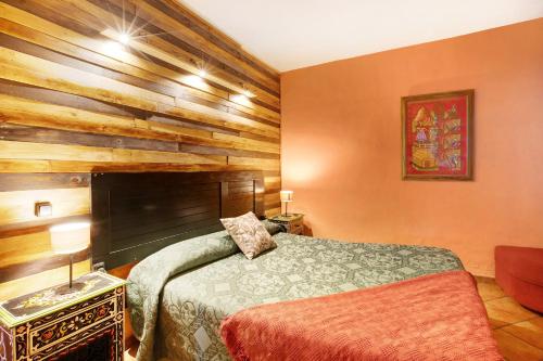 1 dormitorio con 1 cama y pared de madera en Aguamansa Relax, en La Orotava