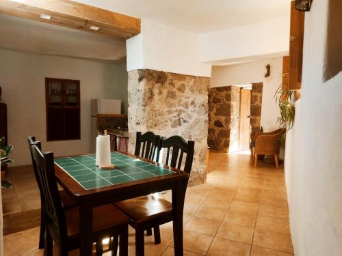 a kitchen and dining room with a table and chairs at Casas cuevas, Los Cabucos in Agaete