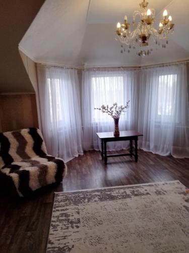 a living room with a couch and a table with flowers at SunLake Hotel Osokorki in Kyiv