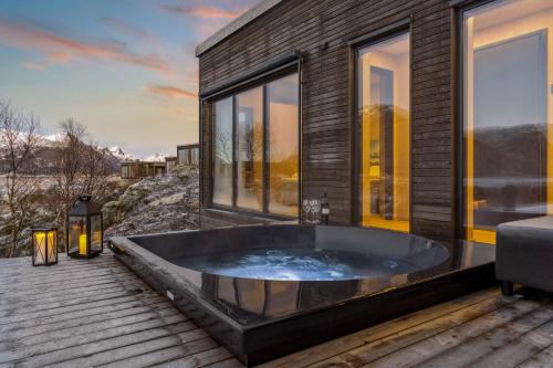 a jacuzzi tub on the deck of a house at Luksushytte sentralt i Lofoten in Kleppstad