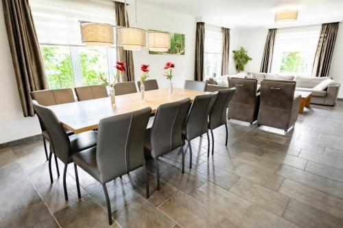 a dining room with a wooden table and chairs at Summio Vakantiepark De Riethorst in Plasmolen