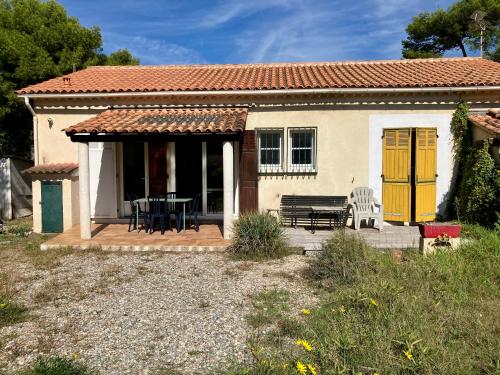 Casa pequeña con puertas amarillas y patio en Maison bord de mer, en Hyères