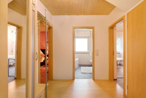 un pasillo con una puerta que conduce a un baño en Sandra, en Berghülen