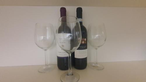 trois verres à vin et une bouteille de vin dans l'établissement MERCADANTE - Luxury Holiday House, à Cassano delle Murge