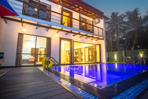 a house with a swimming pool in front of a house at Villa Senaya in Galle