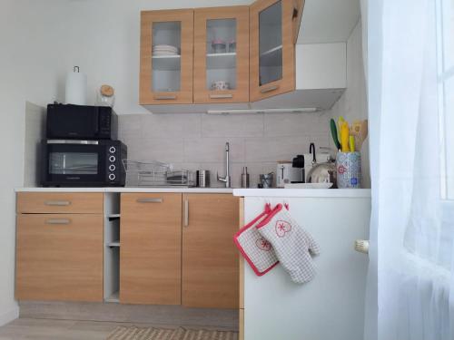 - une petite cuisine avec des placards en bois et un four micro-ondes dans l'établissement Studio, à Saint-ouen-dʼAunis
