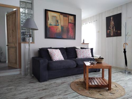 uma sala de estar com um sofá azul e uma mesa em Studio em Saint-ouen-dʼAunis