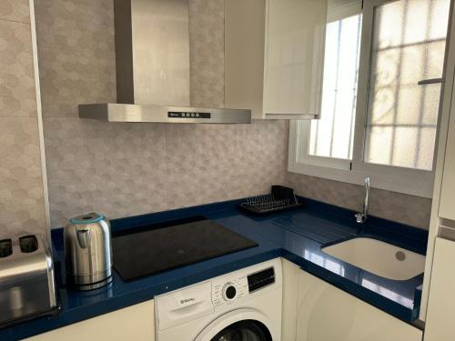 a kitchen with a sink and a washing machine at Nina's crib 2BR flat in Boliches in Fuengirola