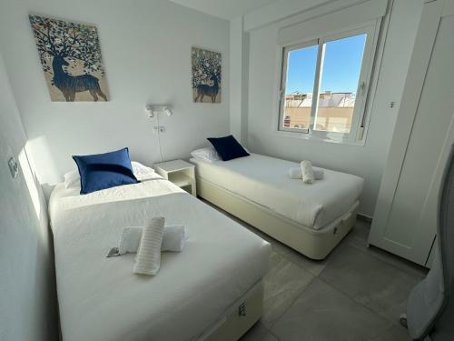 a bedroom with two beds and a window at Nina's crib 2BR flat in Boliches in Fuengirola