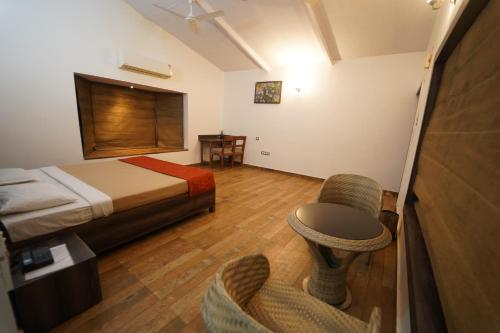een hotelkamer met een bed en een stoel bij Wild Woods Tiger Resort in Nagpur