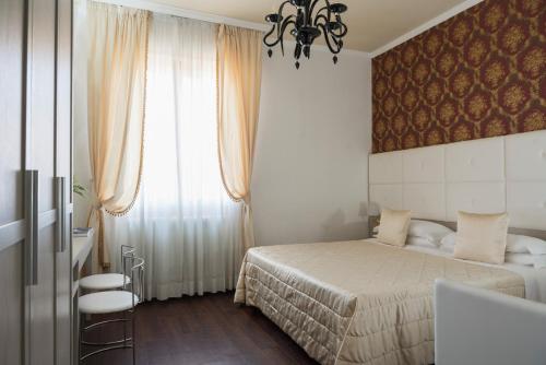 a bedroom with a bed and a window at Hotel Re Enzo in Bologna