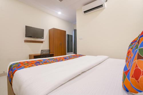 a bedroom with a bed and a tv on the wall at FabHotel Air Live - Nr Ameerpet metro station in Hyderabad