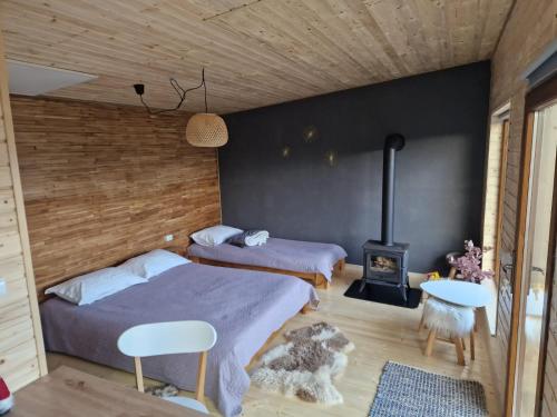a bedroom with two beds and a wood wall at La Odai in Bran