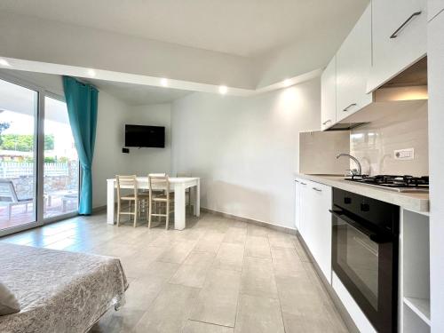 a kitchen and dining room with a table and a counter at Angolo Mare Apartments & Rooms in Porto Pino