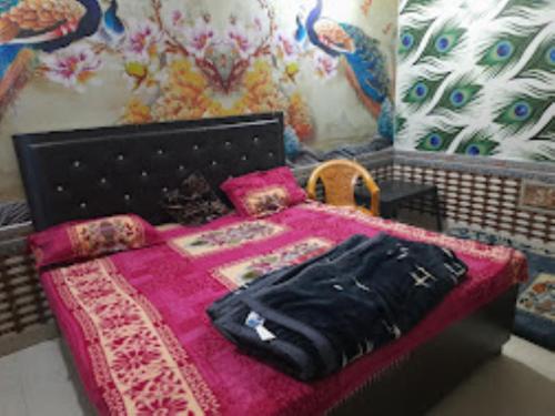 a bedroom with a bed with a pink blanket at Hotel Rajdarbar Fatehpur in Fatehpur Sīkri