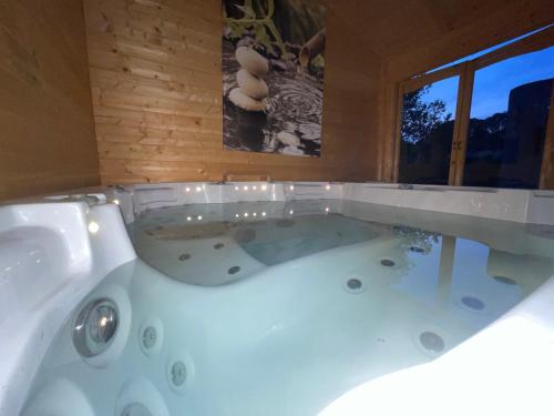 a bath tub in a room with a window at La maison de la Cigale in Forcalqueiret