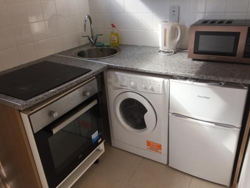 a kitchen with a sink and a washing machine at South Dublin Flat near Killiney Beach! in Loughlinstown