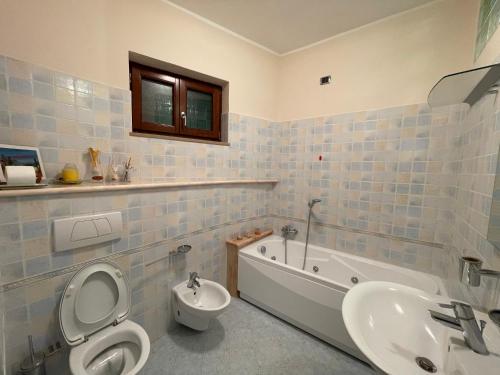 a bathroom with a toilet and a tub and a sink at La casa di Mene & Lù in Pesche
