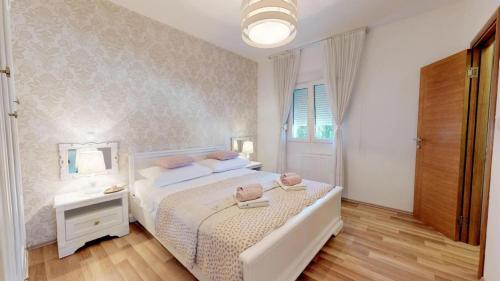 カシュテラにあるXXL Luxury villa near Split for up to 16 peopleのベッドルーム(白いベッド1台、鏡付)