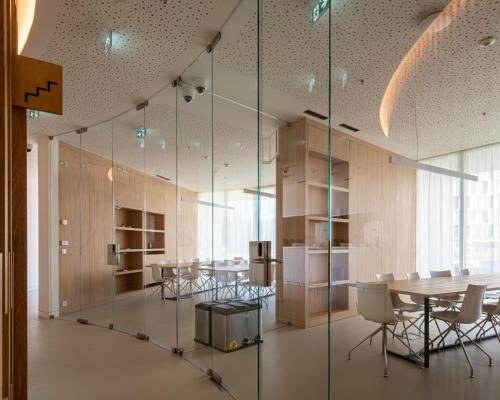 uma sala de conferências com paredes de vidro, mesas e cadeiras em micampus Porto Tower no Porto