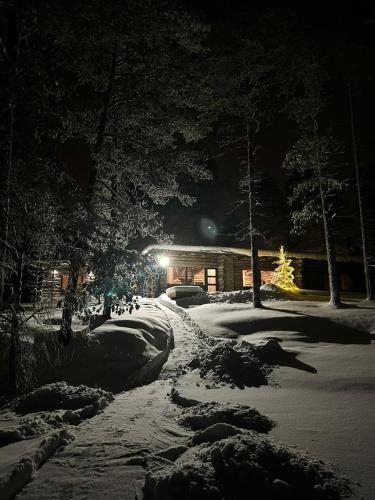a snow covered street at night with a house at Villa Uuttu in Kuusamo