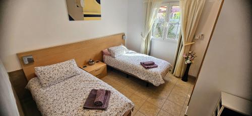 a small room with two beds and a window at Verano Brisa Private Golf Villa in Caleta De Fuste