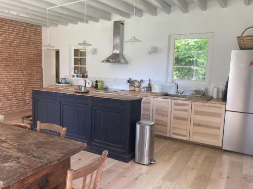 Il comprend une cuisine équipée d'un réfrigérateur et d'une table. dans l'établissement Lanterne, à Longueil