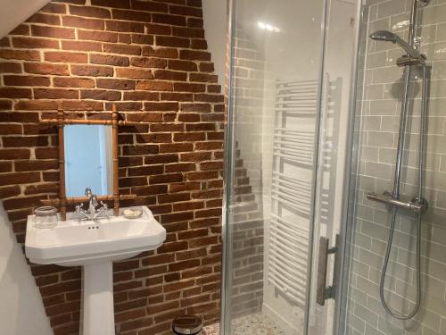 une salle de bain avec un lavabo et une douche en verre dans l'établissement Lanterne, à Longueil