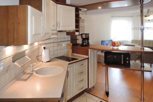 a kitchen with a sink and a microwave at Apartament Pod Wieżyczkami in Międzyzdroje