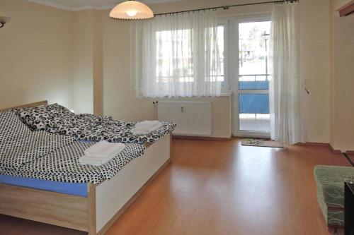 a bedroom with a bed and a large window at Apartament Pod Wieżyczkami in Międzyzdroje