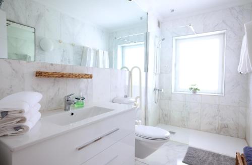 a white bathroom with a sink and a toilet at Sun Club Playa del Ingles in Playa del Ingles