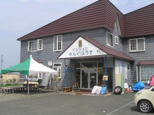 a building with a sign on the front of it at Pension Young House in Furano