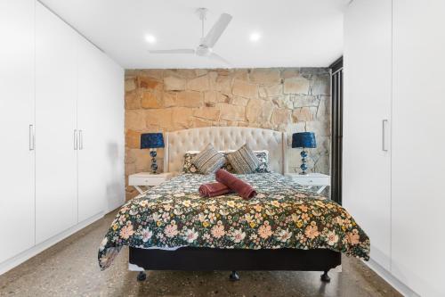 a bedroom with a bed and a stone wall at Unique and Modern Farm Stay with Pool and Foosball and Yard in Buninyong