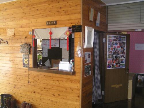 eine Holzwand mit einer Theke in einem Zimmer in der Unterkunft Pension Young House in Furano