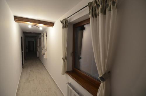 a hallway with curtains and a window on a wall at Pensiunea Banffy in Topliţa