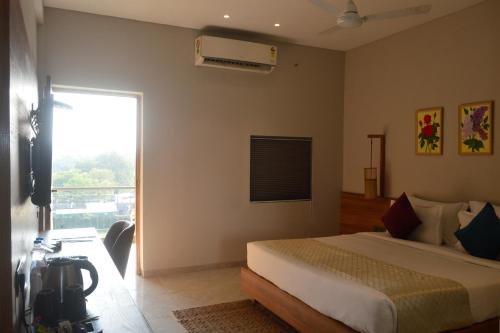 a bedroom with a bed and a window and a camera at Pathikashram Nilaya in Gandhinagar