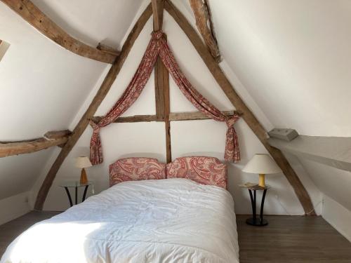 Un dormitorio con una cama en un ático en Proleps, en Varengeville-sur-Mer
