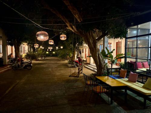 a patio at night with a table and chairs at Eden House & Coffee Con Dao in Con Dao