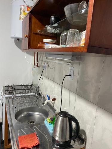 a kitchen counter with a sink and a tea kettle at Cabañas del Chachi in Oberá