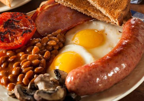 a plate of breakfast food with eggs sausage beans and toast at Elstree Inn in Borehamwood