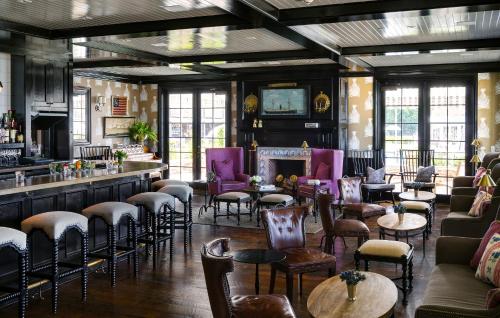 a bar with chairs and tables in a room at Baron's Cove in Sag Harbor