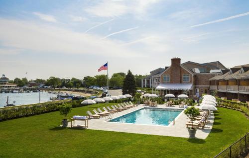a swimming pool with lounge chairs and a house at Baron's Cove in Sag Harbor
