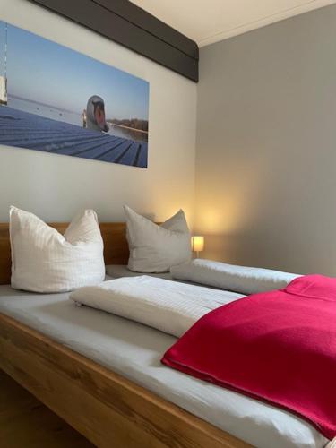 ein Schlafzimmer mit einem Bett mit einem Bild an der Wand in der Unterkunft Quartier Scharmützelsee in Bad Saarow