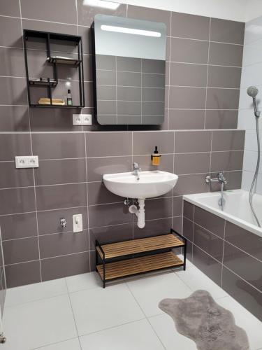 a bathroom with a sink and a mirror and a tub at Apartmán Senica in Senica